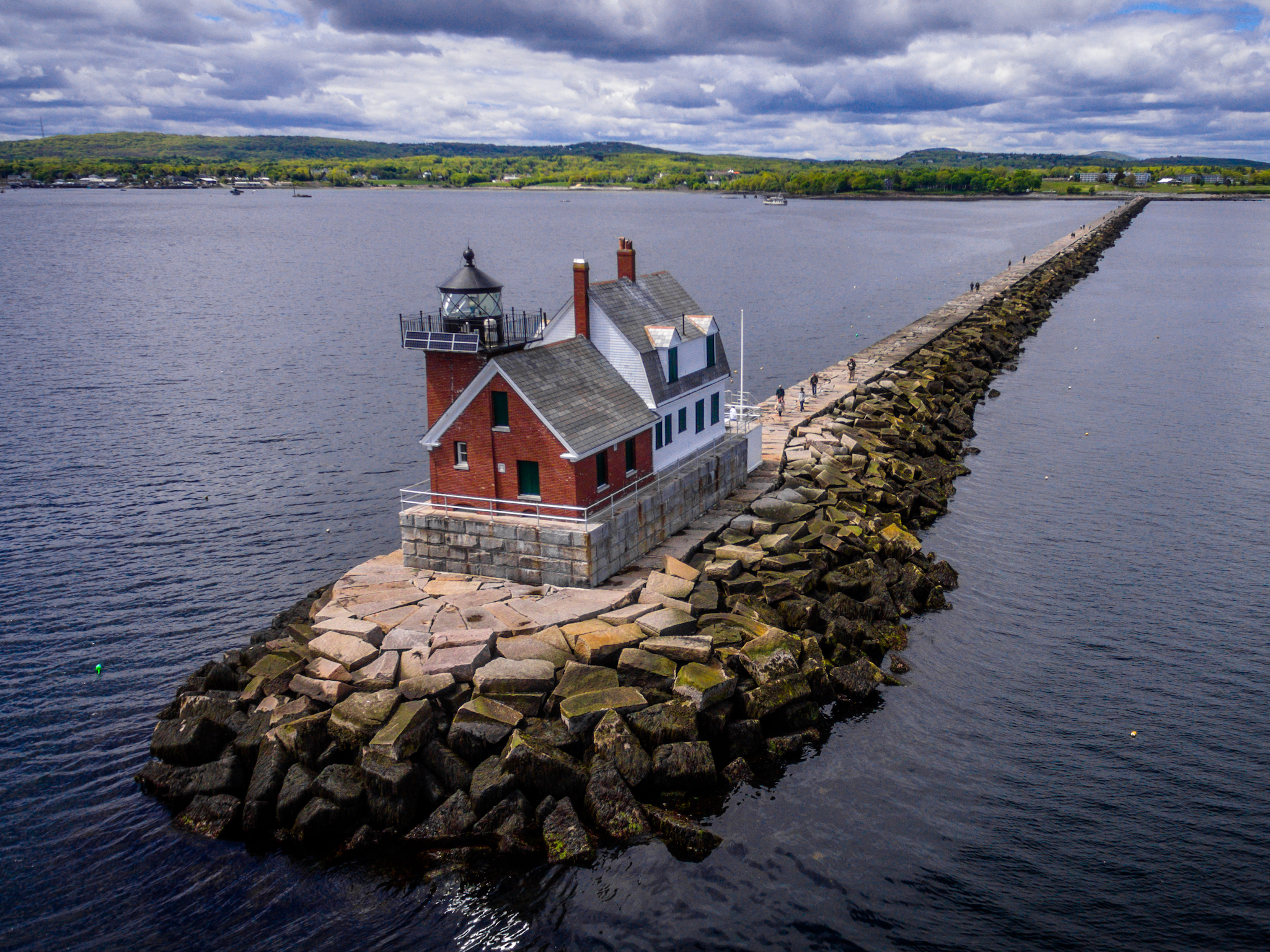 Rockland Breakwater Lighthouse on the coast of Rockland Maine with a long stone pier.