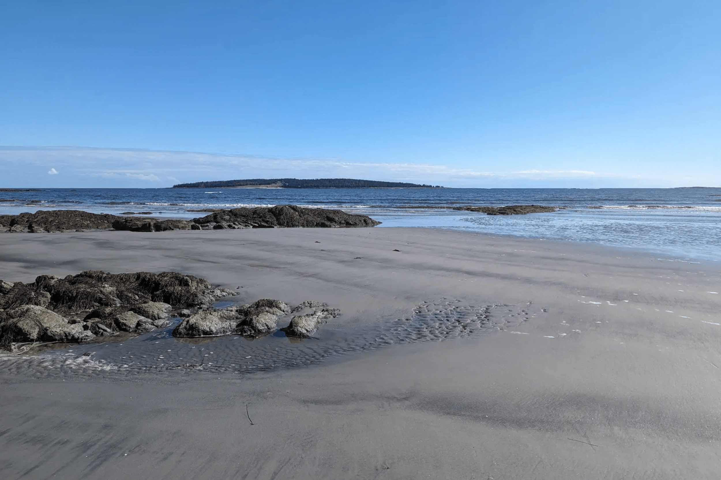 Sandy Beach in Cushing Maine at low tide with rocks and ocean view