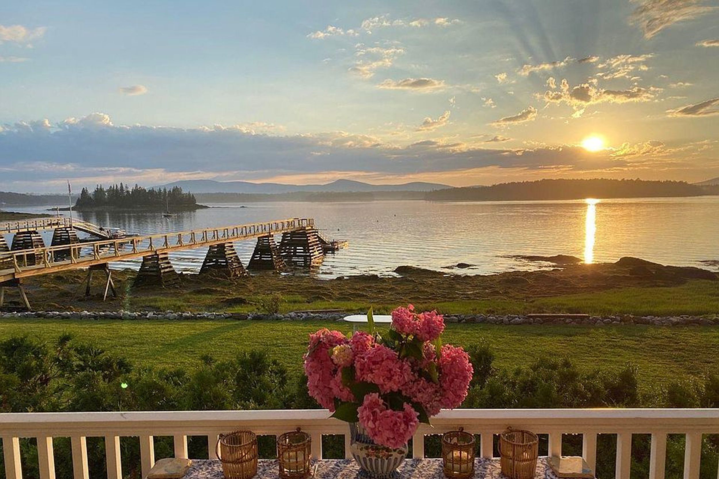 Islesboro Maine waterfront view with lobster traps, dock, and sunset over Penobscot Bay