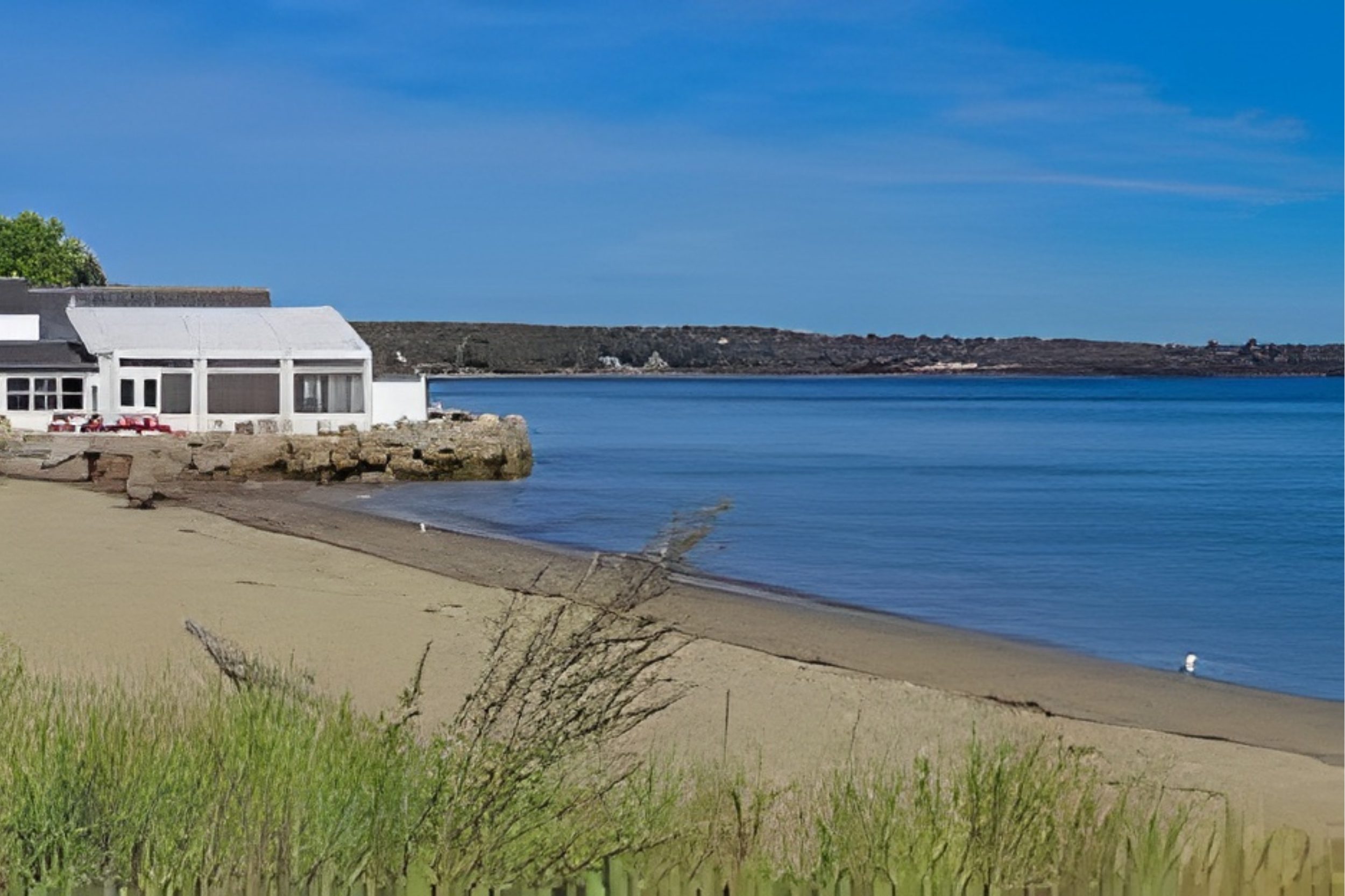 Lincolnville Beach Maine with sandy shoreline, waterfront buildings, and ocean view