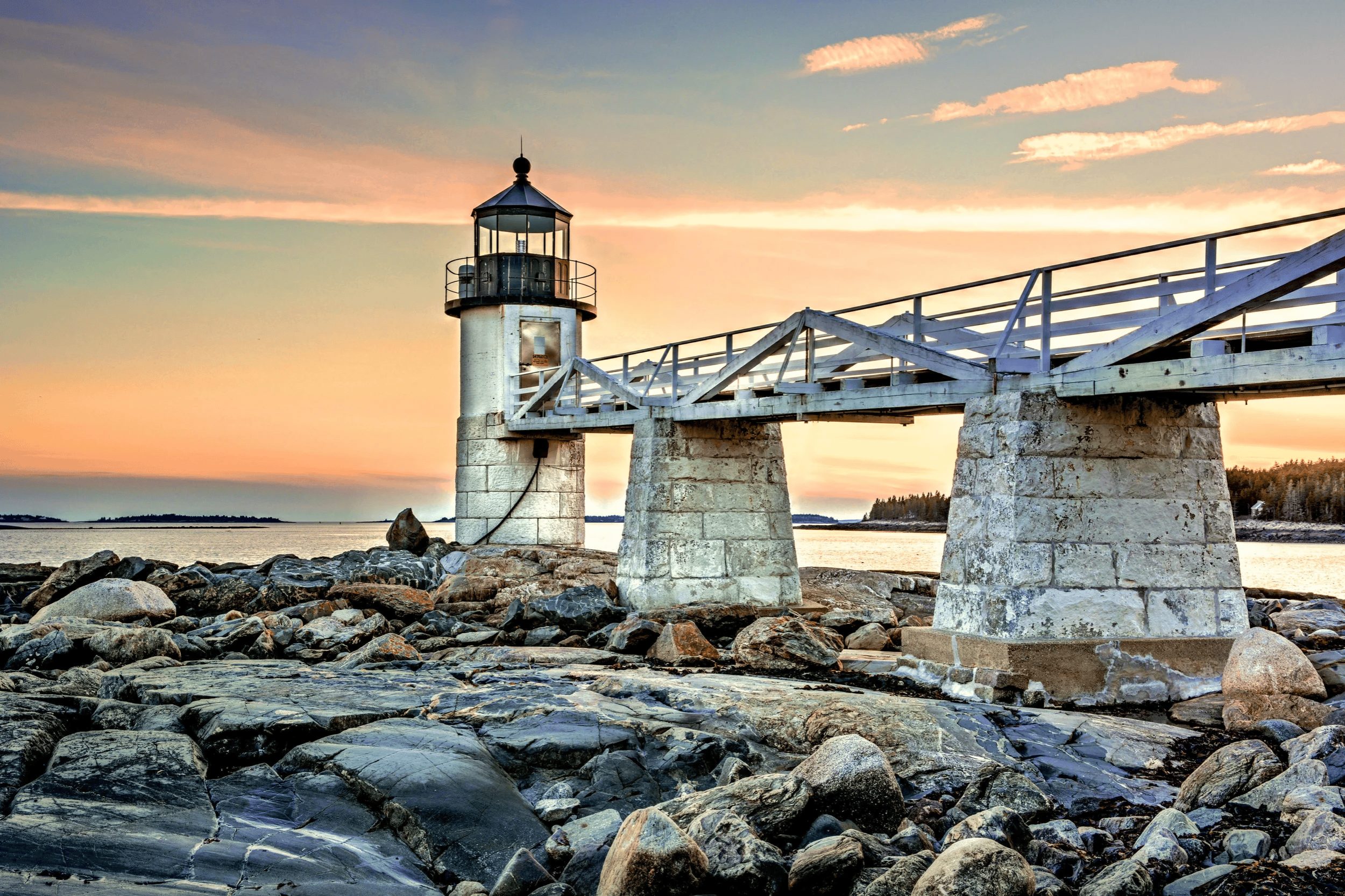Marshall Point Lighthouse in Cushing Maine with wooden walkway over rocky shore