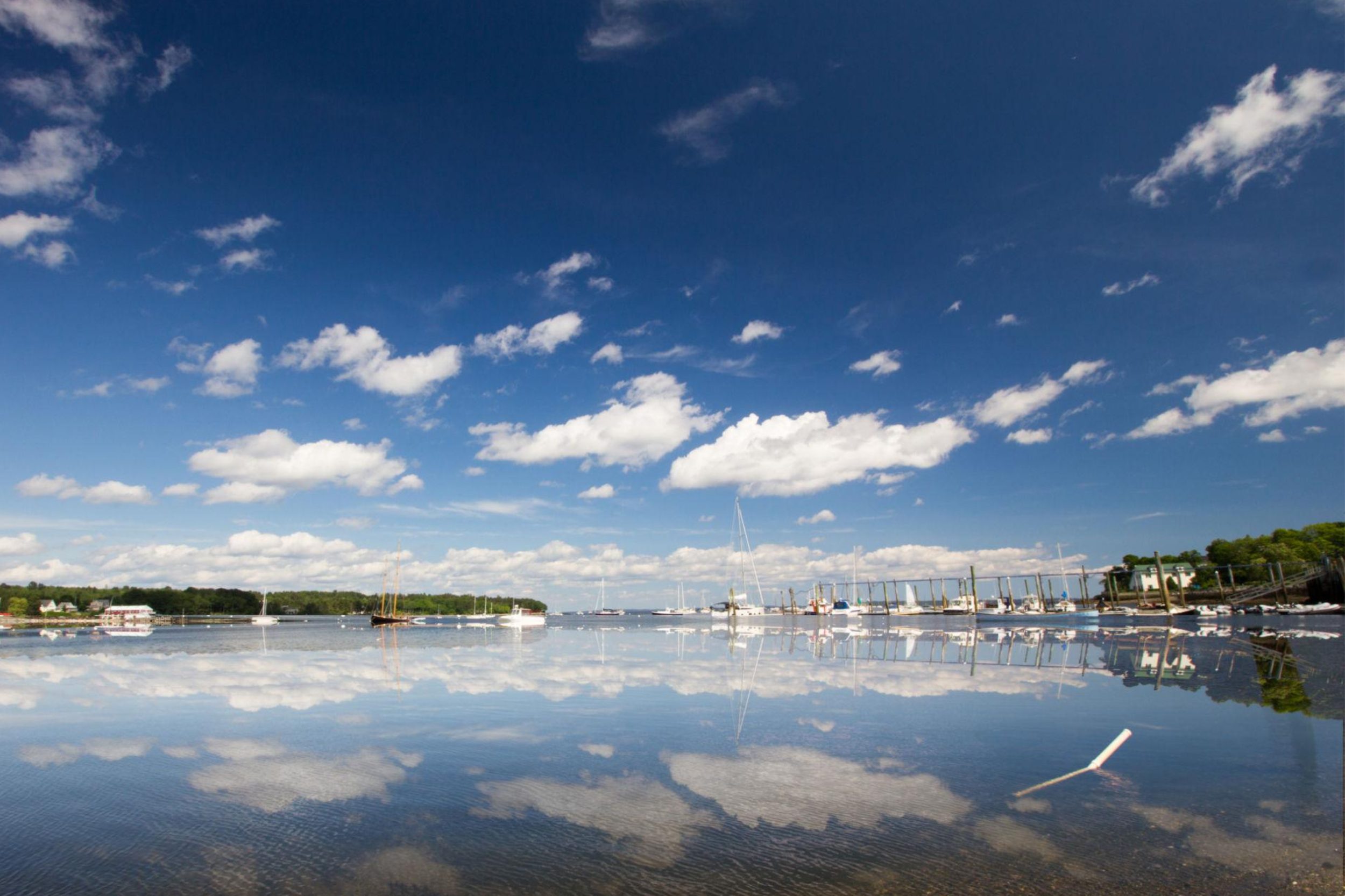 Calm harbor waters with anchored boats along the Northport Maine coastline
