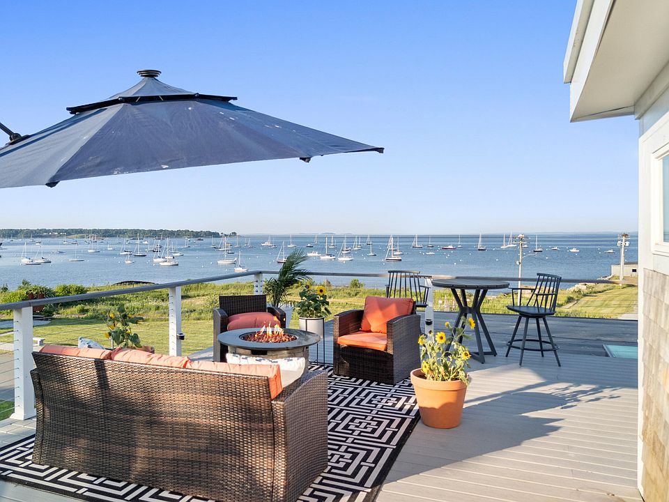 Waterfront home deck in Rockland Maine overlooking harbor with boats and outdoor seating