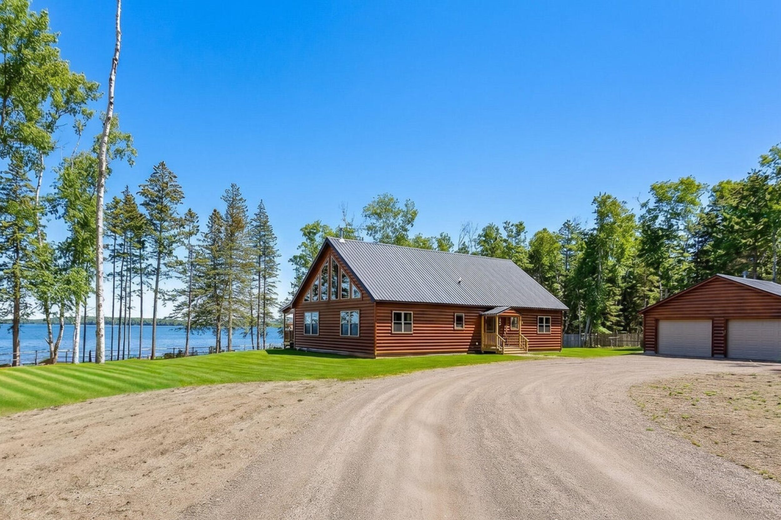 Waterfront log-style home with detached garage at 1590 Pripet Woods Lane in Islesboro, Maine