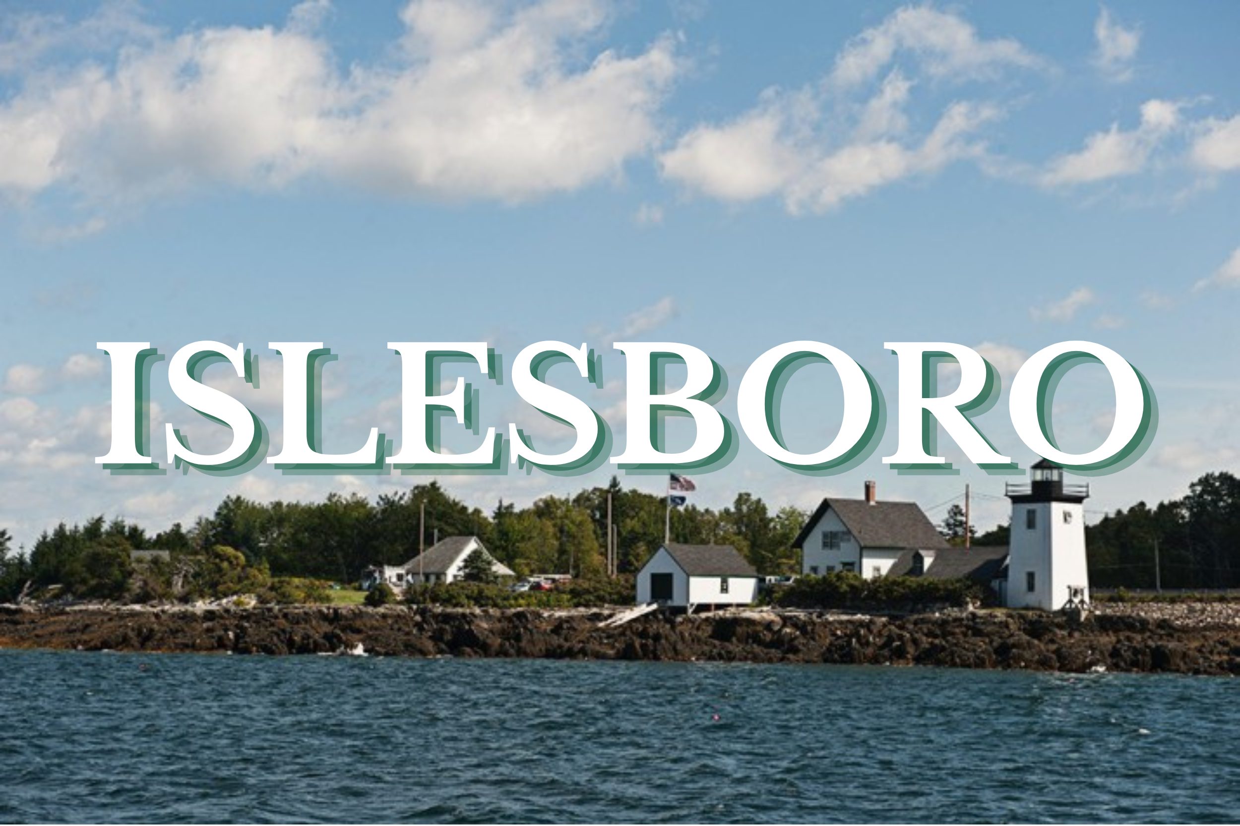 Rocky Maine coastline with lighthouse and waterfront buildings in Islesboro, Maine