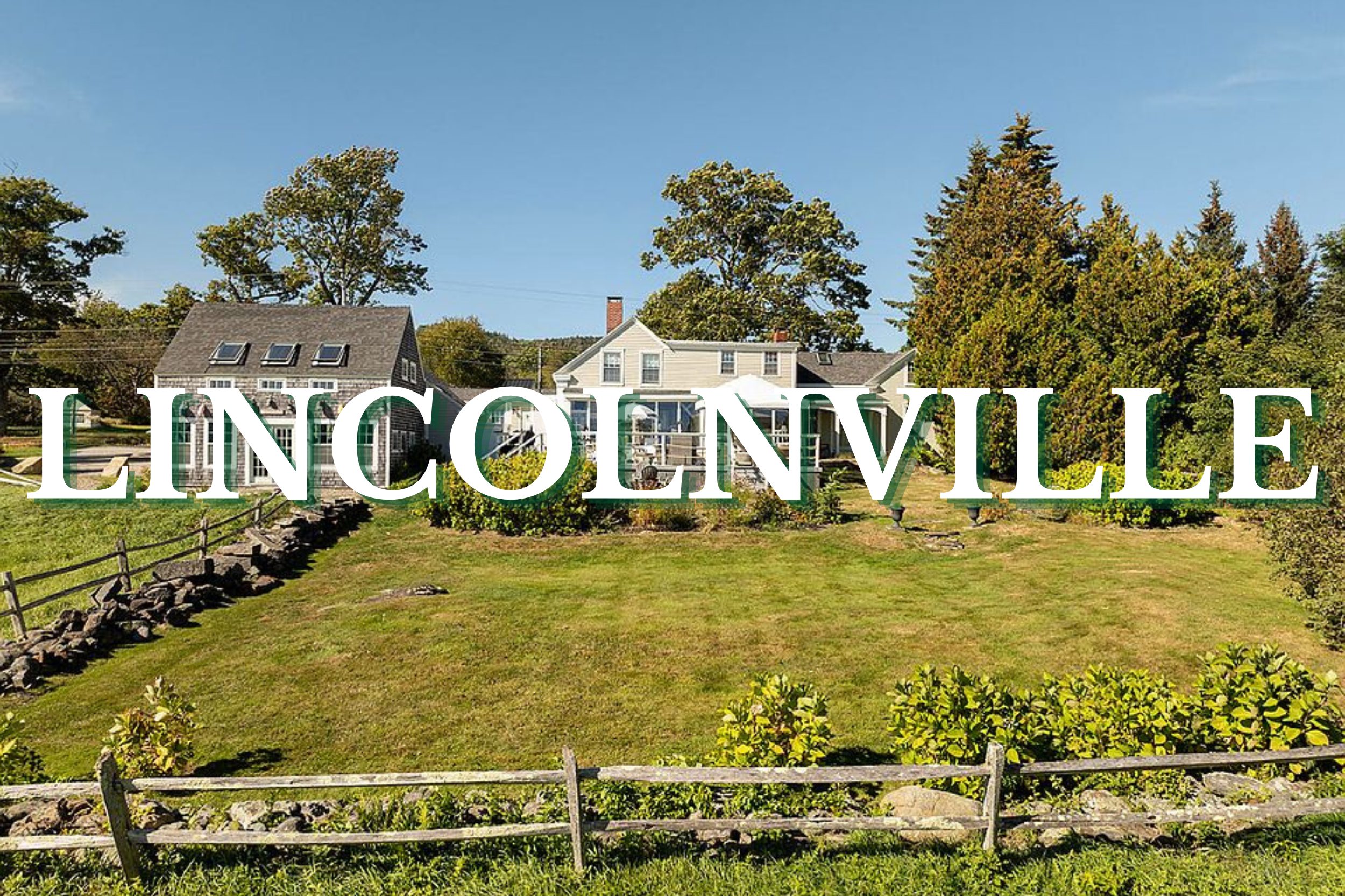 Classic New England home with large lawn and split-rail fence in Lincolnville, Maine
