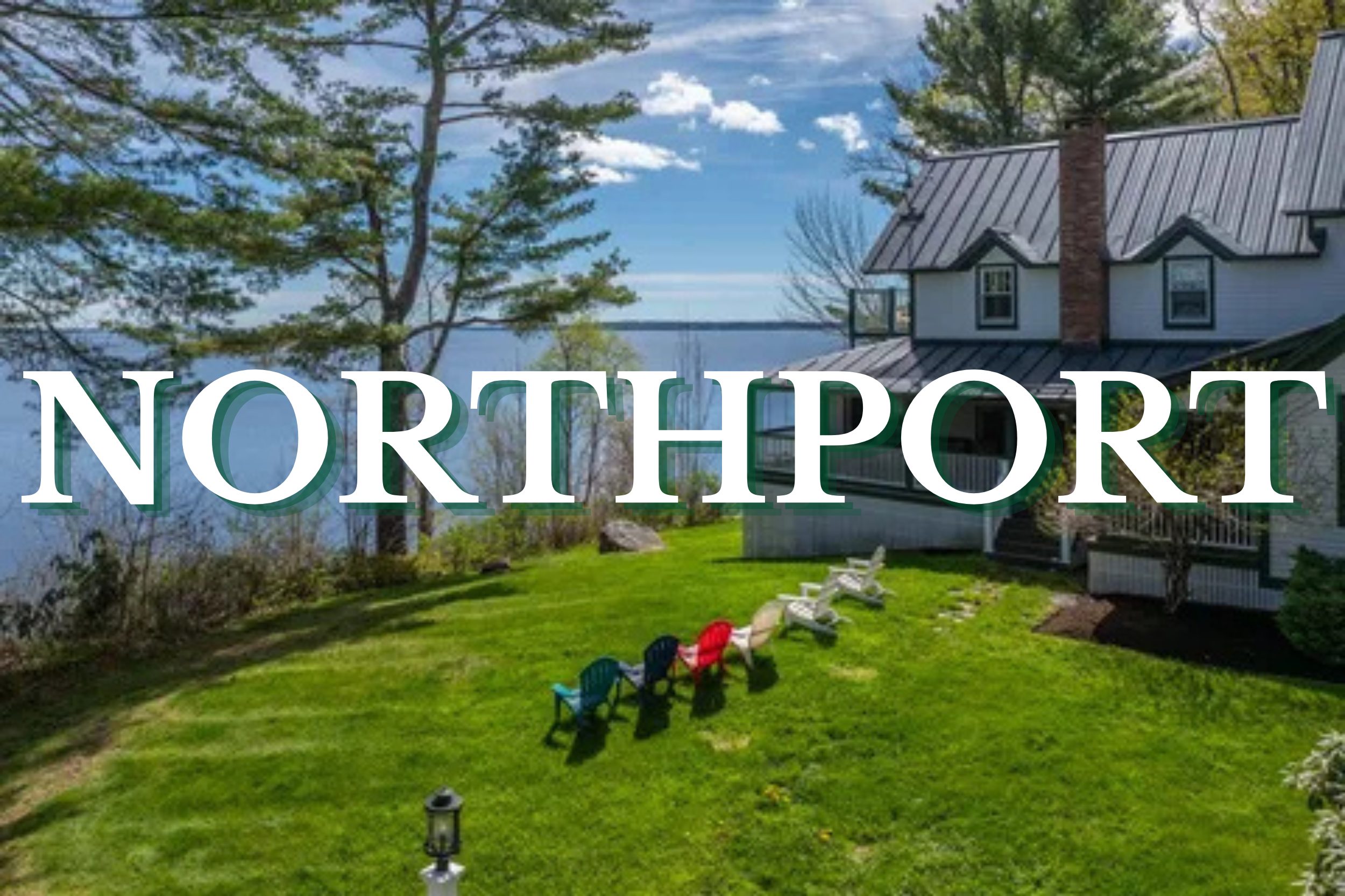 Coastal home overlooking the water with Adirondack chairs on a grassy lawn in Northport, Maine