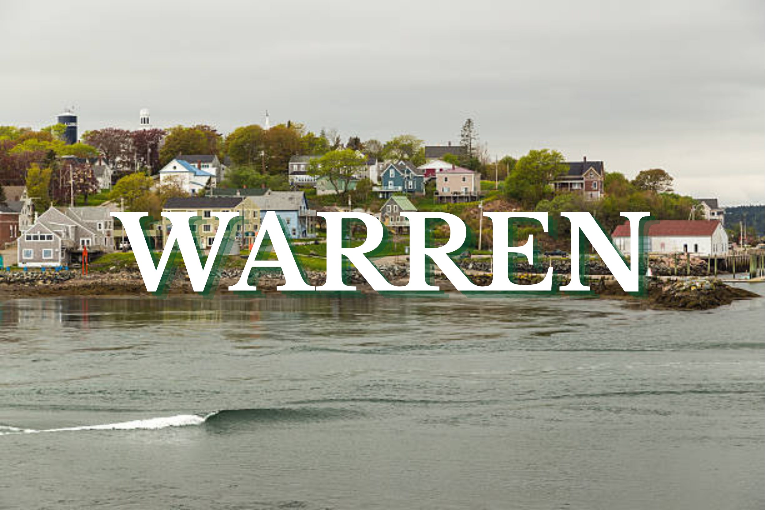 Coastal homes and waterfront shoreline in Warren, Maine viewed across calm water