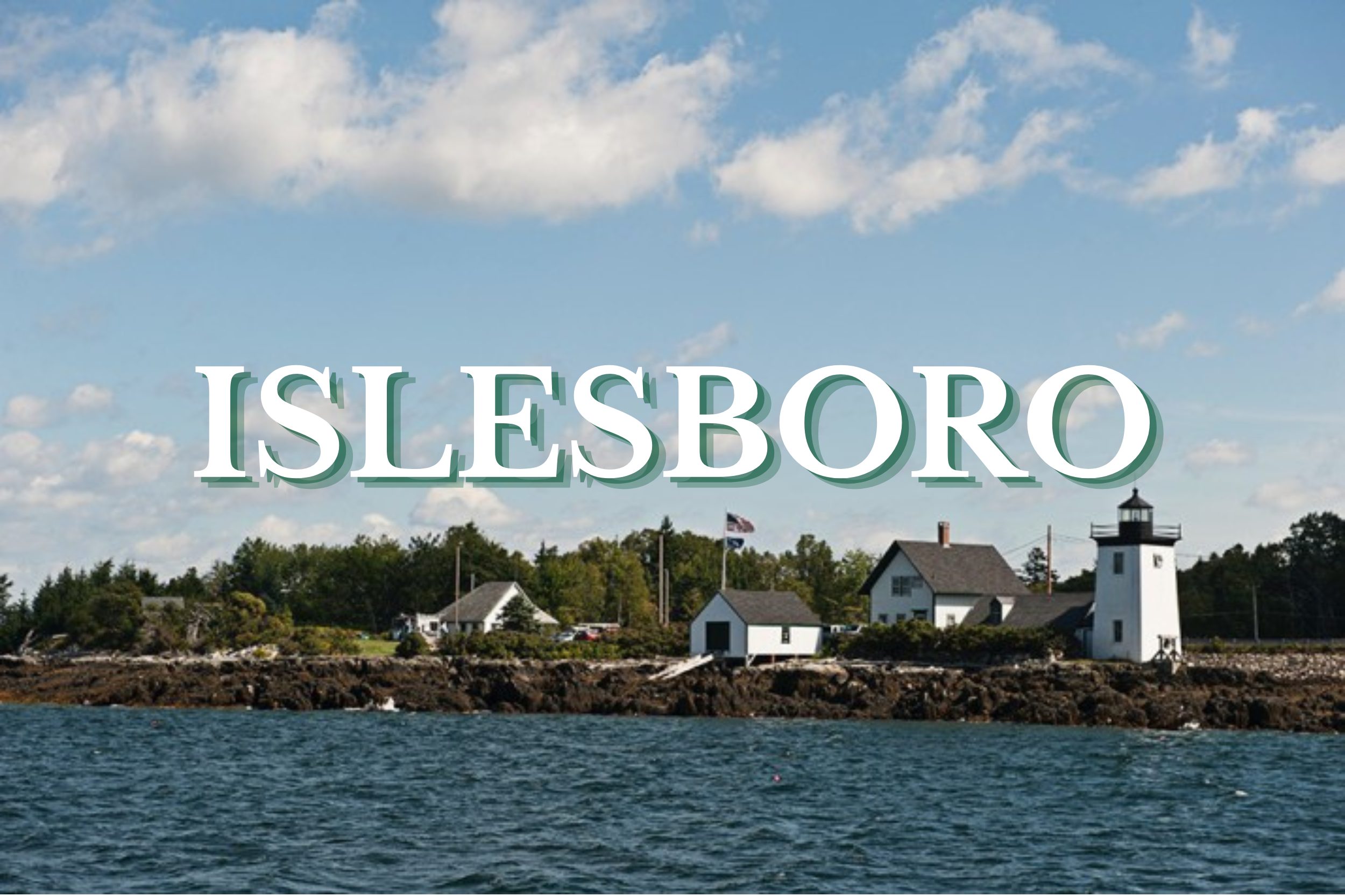 Oceanfront lighthouse and coastal homes along the rocky shoreline in Islesboro, Maine