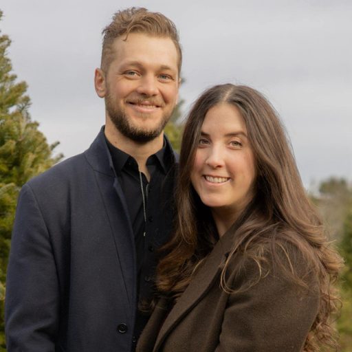 Portrait of Maine real estate professionals Mara and Duryea Decker Griffith standing outdoors and smiling