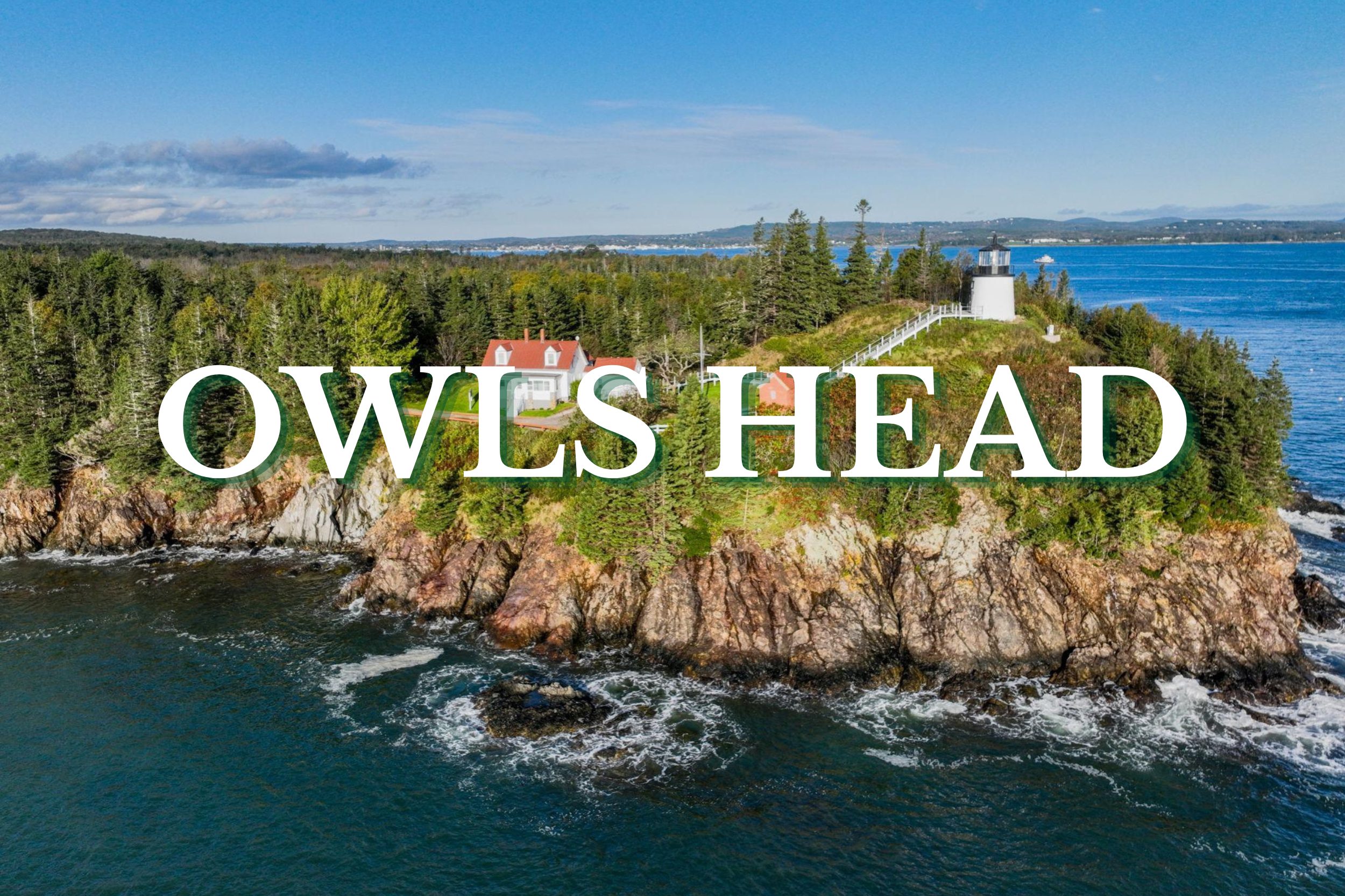 Aerial view of Owls Head Lighthouse perched on a rocky coastal cliff surrounded by ocean and trees