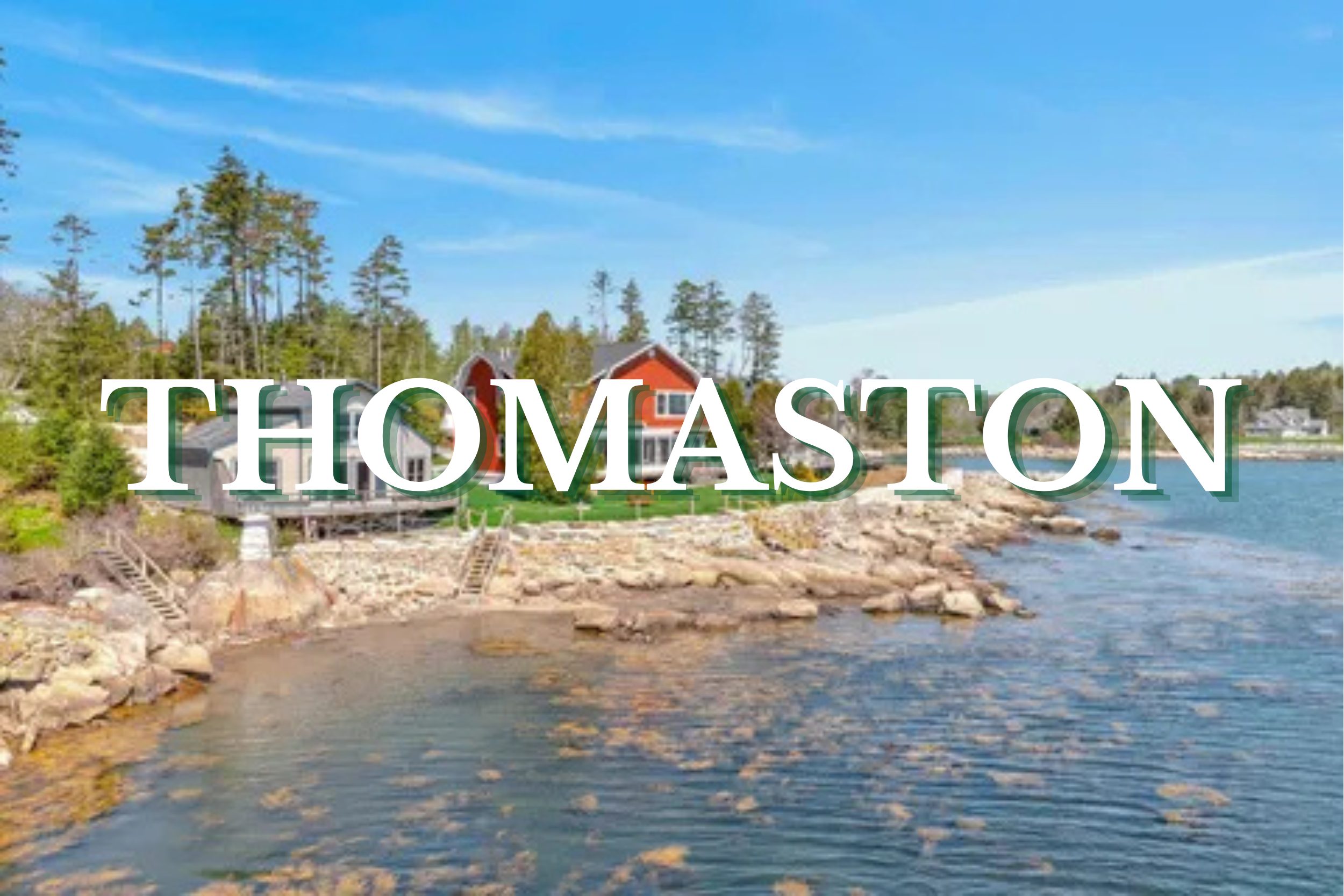 Coastal homes overlooking a rocky shoreline and calm ocean waters in Thomaston, Maine