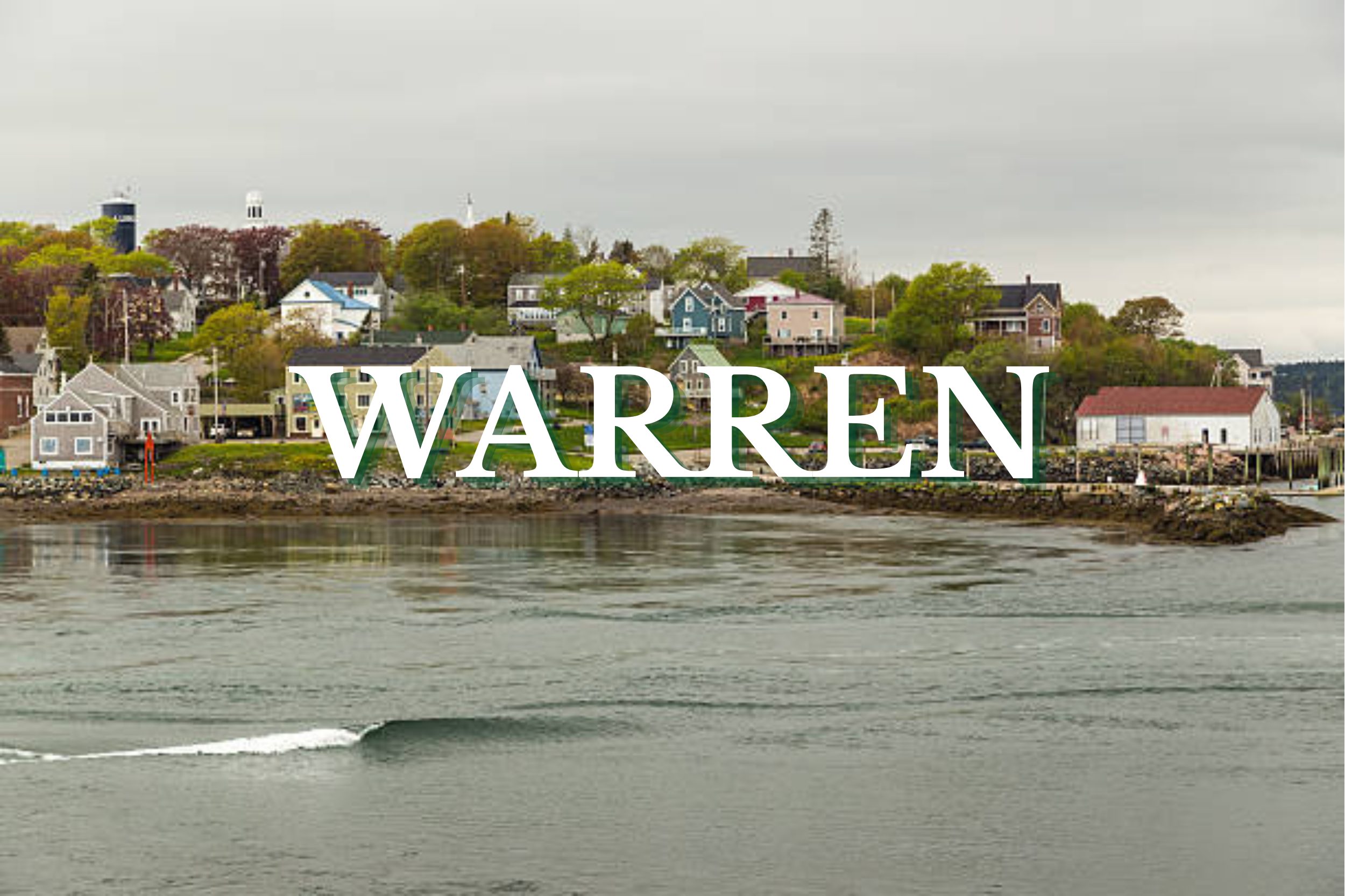 Quiet waterfront village with colorful homes and calm coastal waters in Warren, Maine