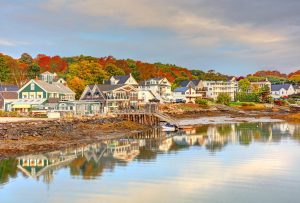 Coastal homes along the Maine waterfront surrounded by colorful fall foliage